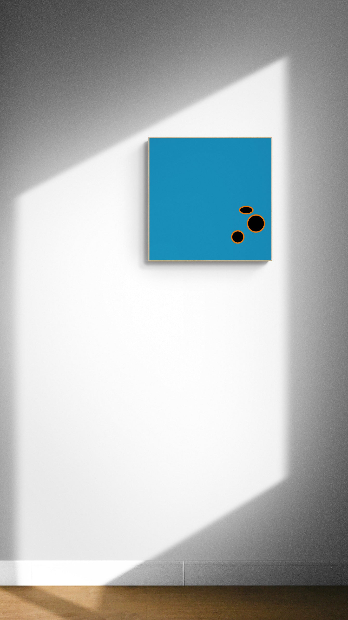 Blue square art print with black and orange circles on a white wall