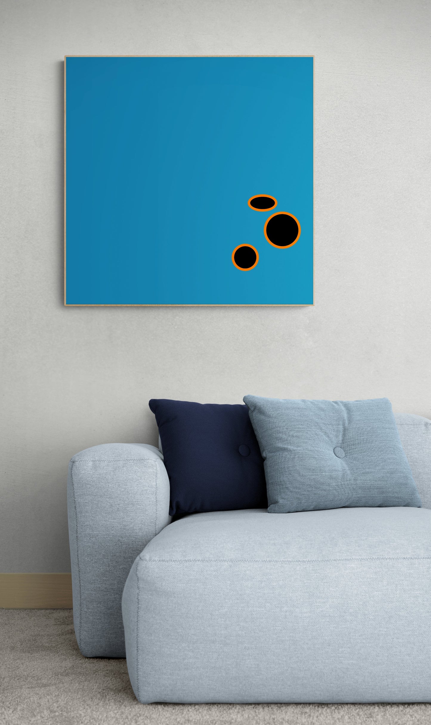 Abstract artwork print with black circles on a blue background in a living room setting.setting.