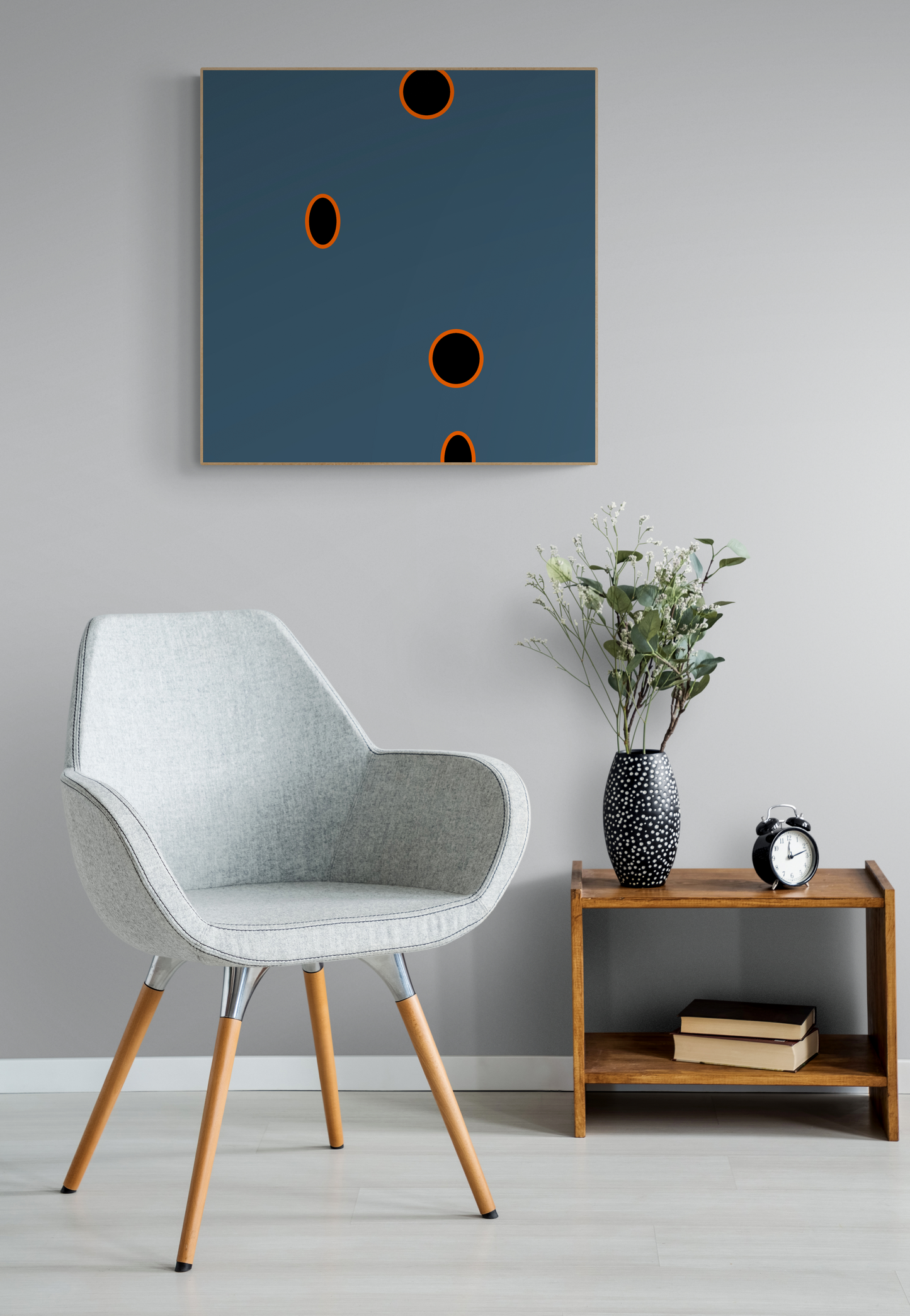 Modern interior with a gray chair, wooden side table, and abstract grey wall art print.