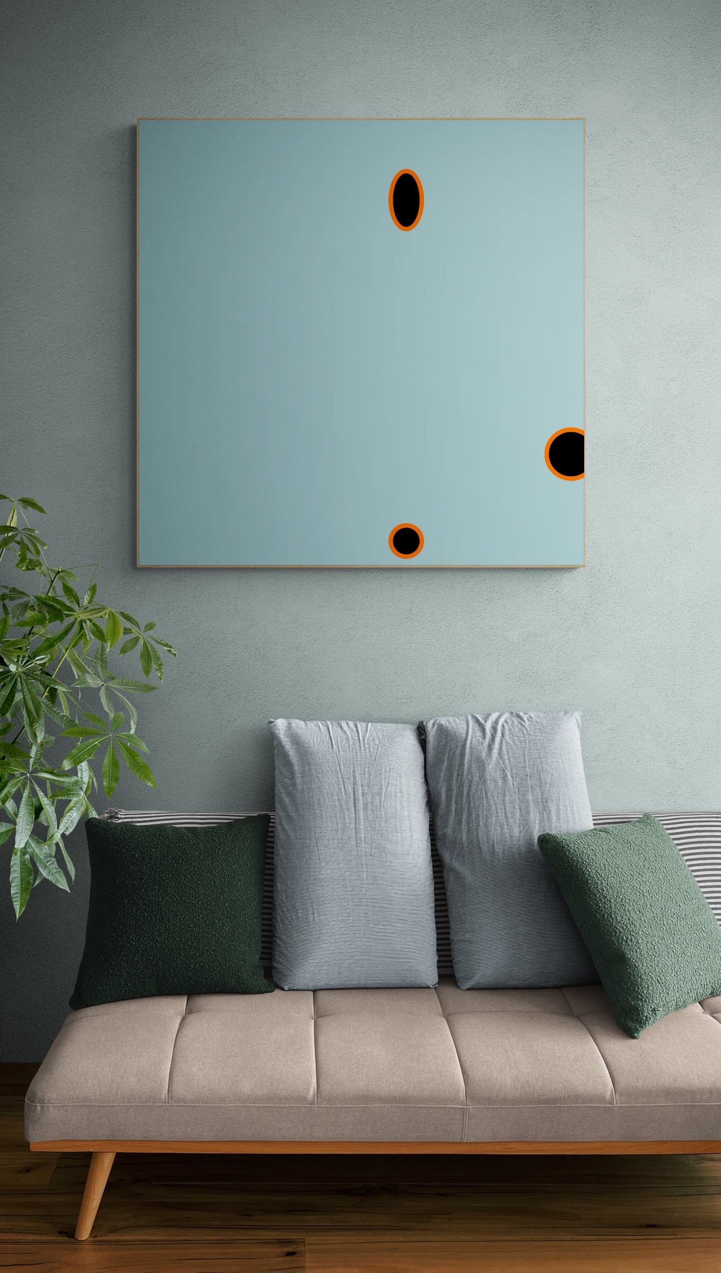 Sofa with decorative pillows against a wall with a large abstract blue print