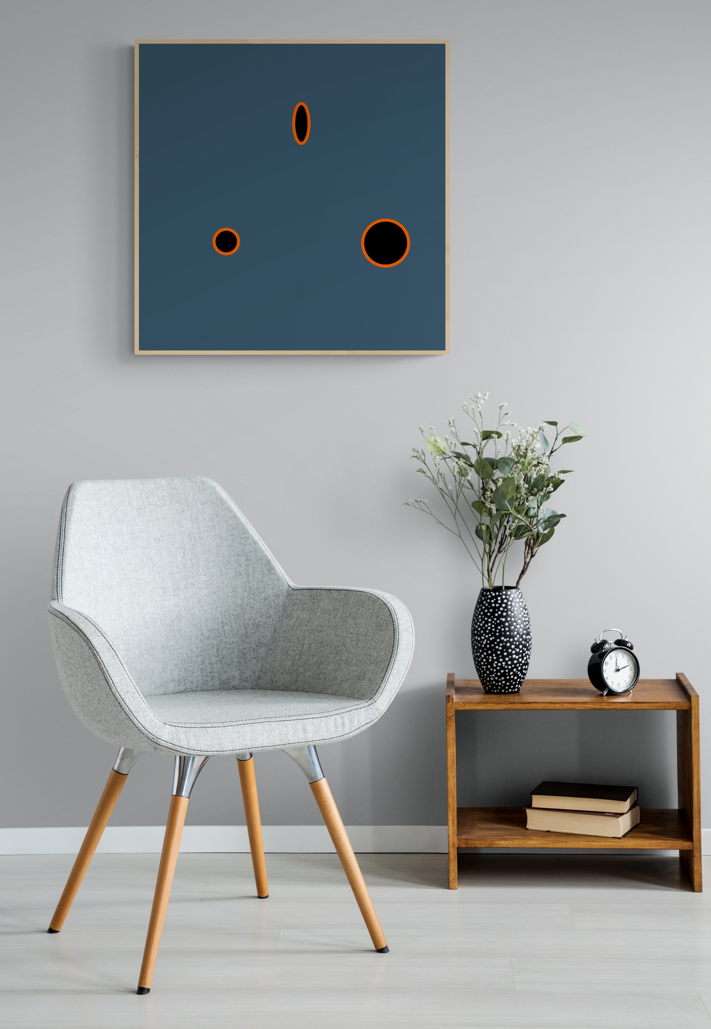 Modern interior with a gray chair, wooden side table, and abstract grey art print on the wall.