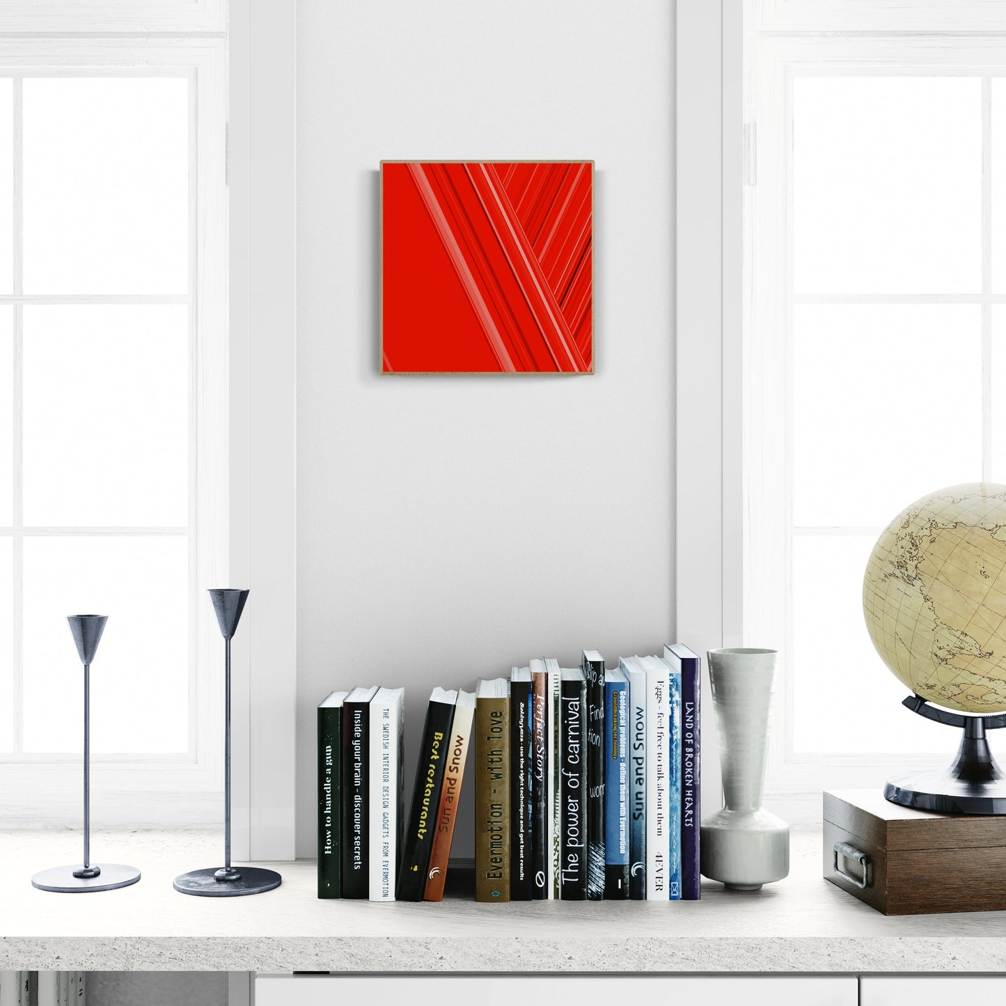 Modern interior with an art print of abstract red design with geometric shapes on a red background, books, and decorative items on a shelf.