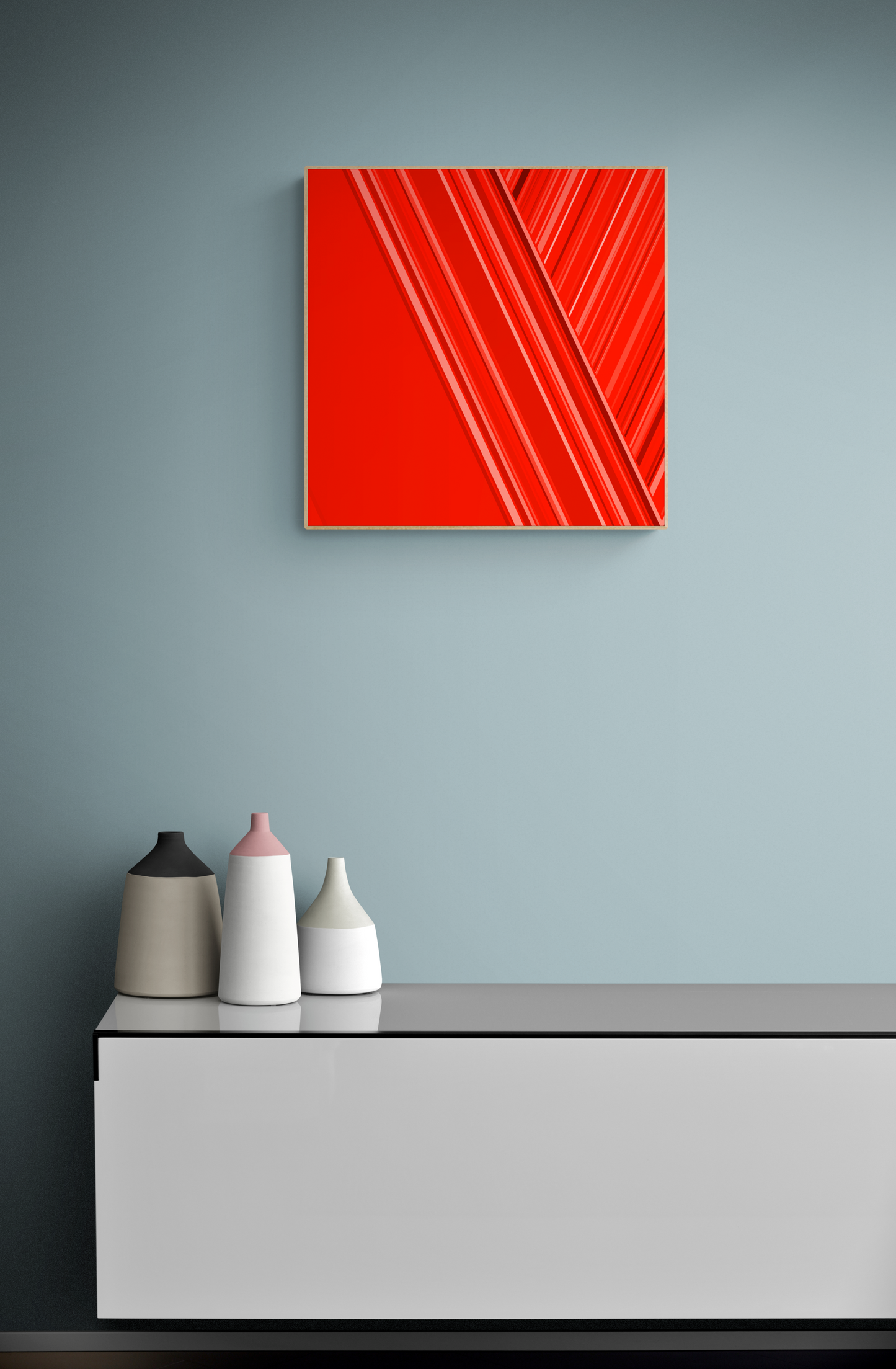 Red abstract art print on a gray wall above a white console table with decorative vases.