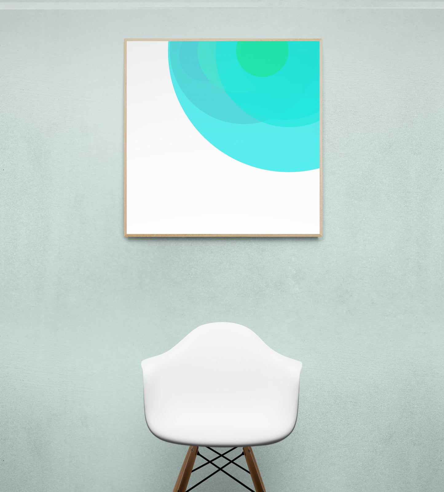 Framed abstract art print with circular design on a light green wall above a white chair.