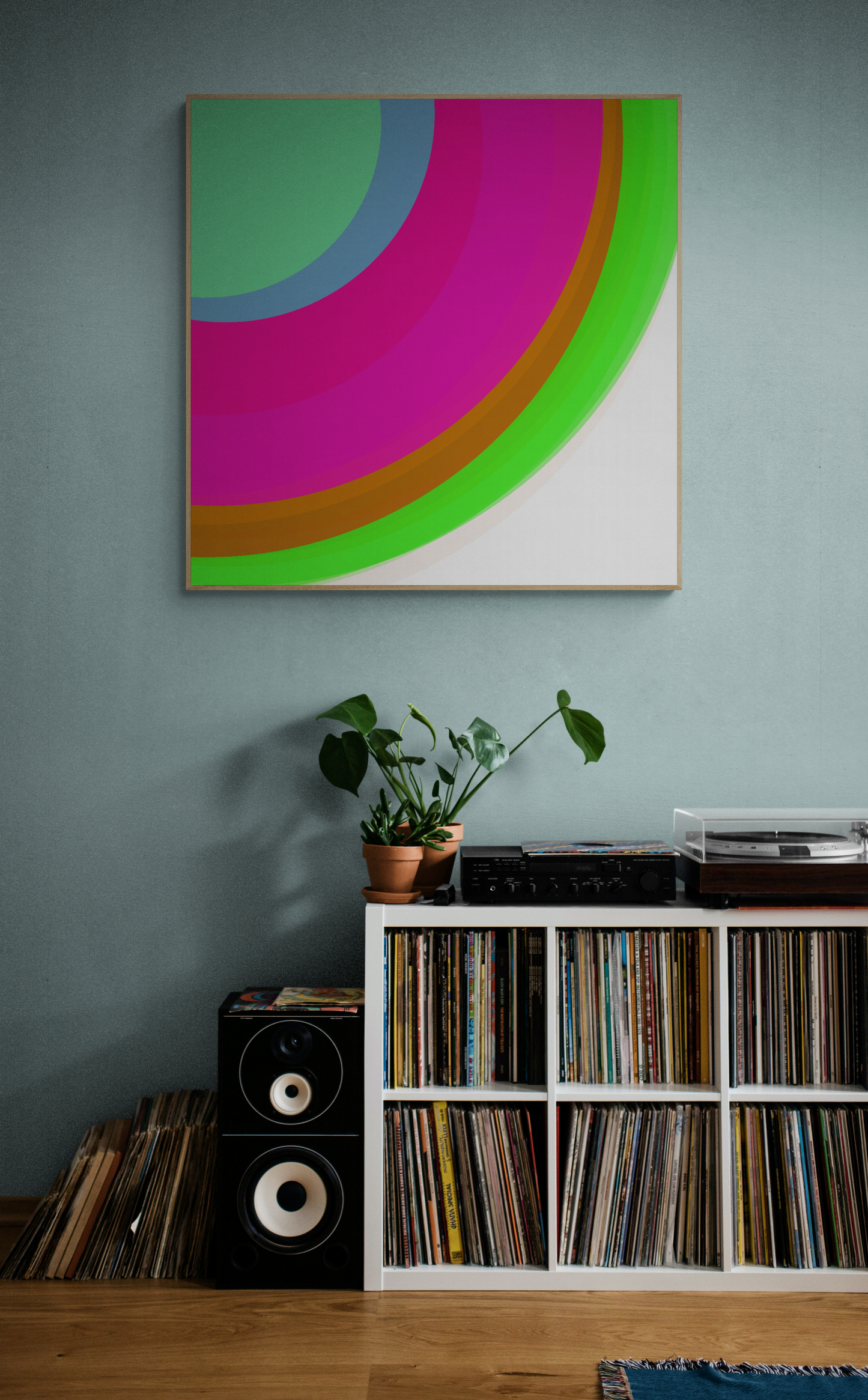 Art print of colorful circular sphere objects on a white background on a wall above a record player and collection of records.