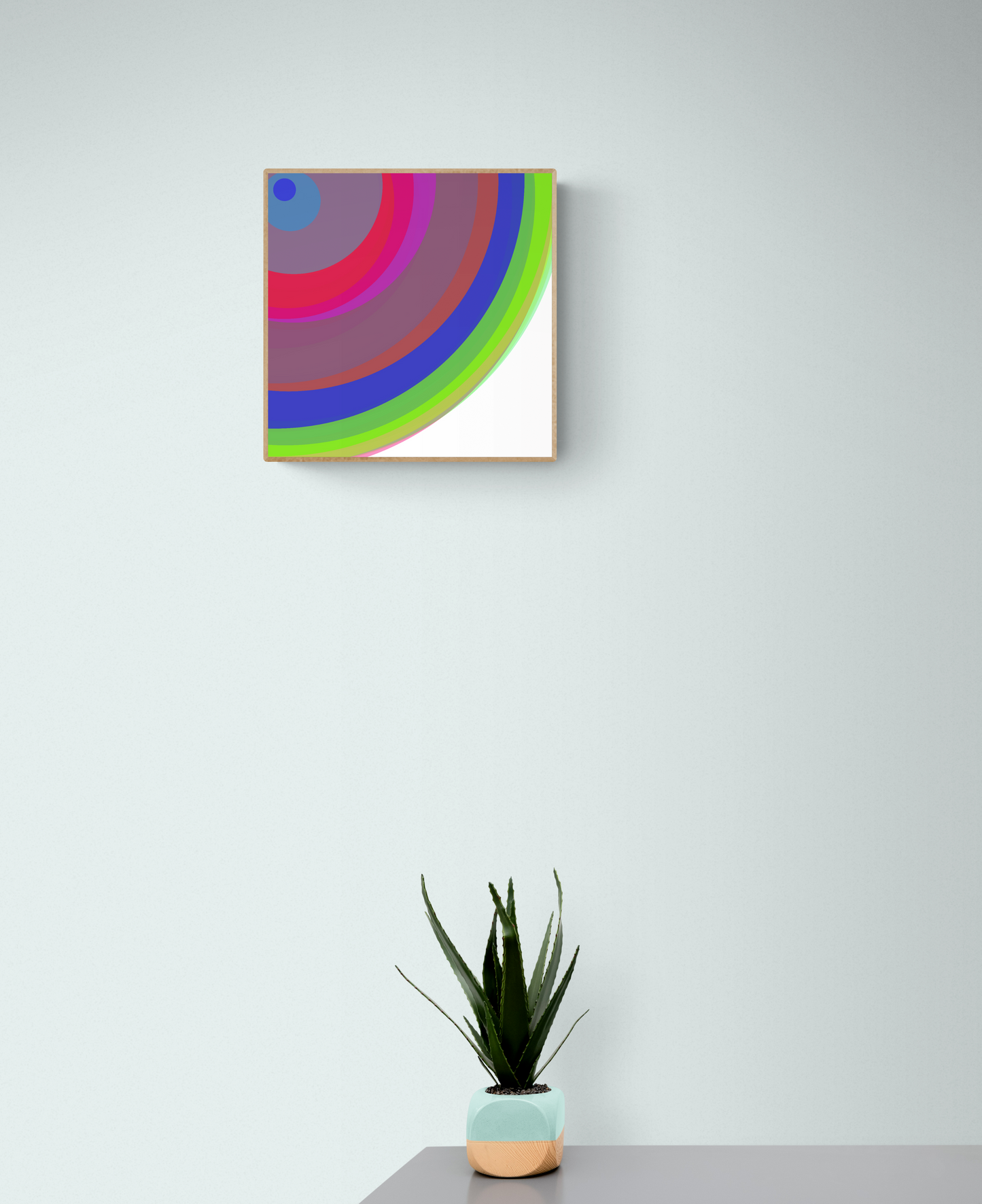 Colorful abstract art print on a white wall with a potted plant below.
