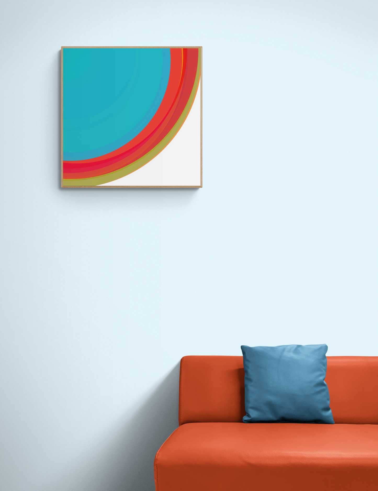 Colorful abstract print on a light blue wall above an orange sofa with a blue pillow.