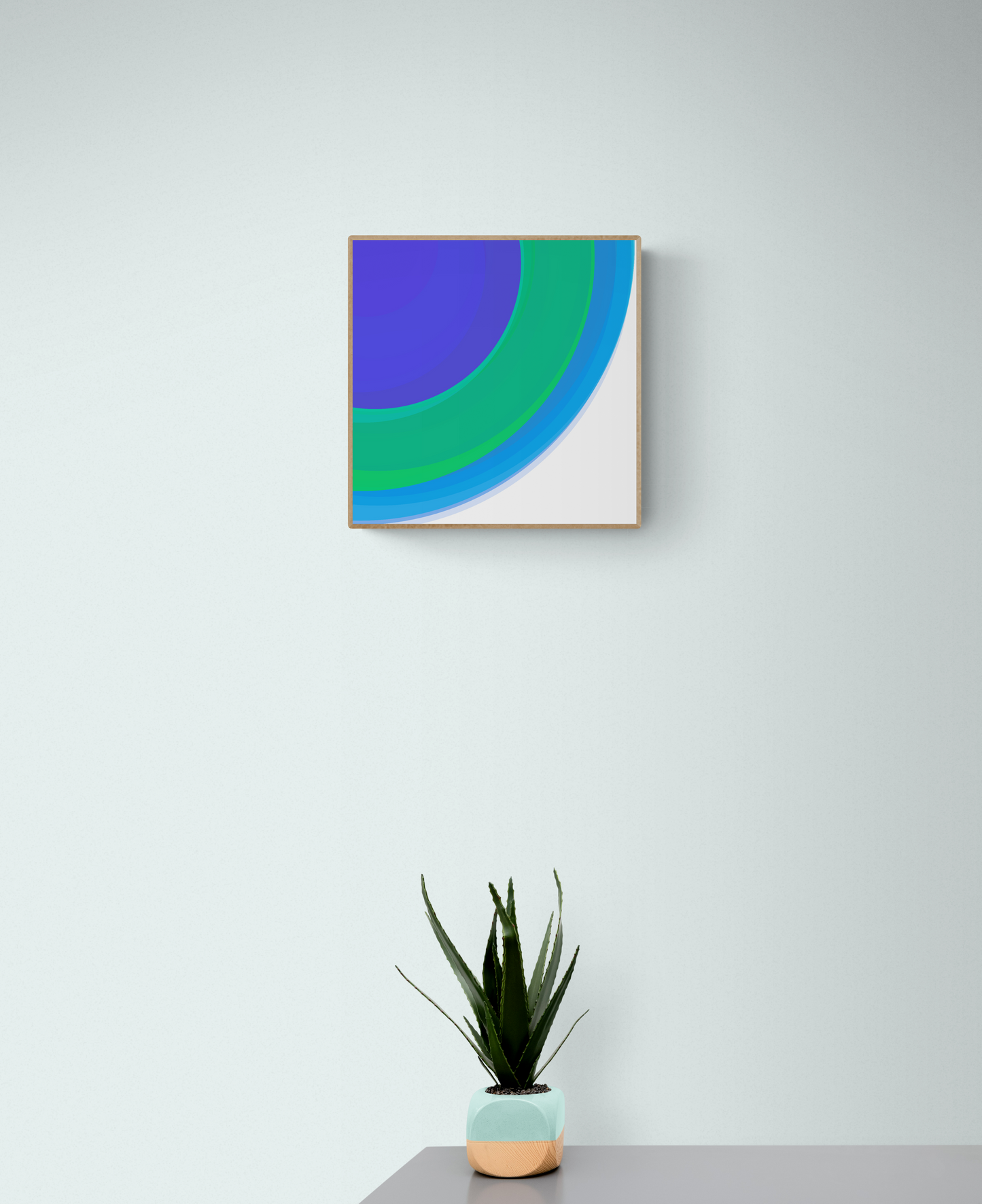 Abstract art print with blue and green colors on a white wall, accompanied by a potted plant.