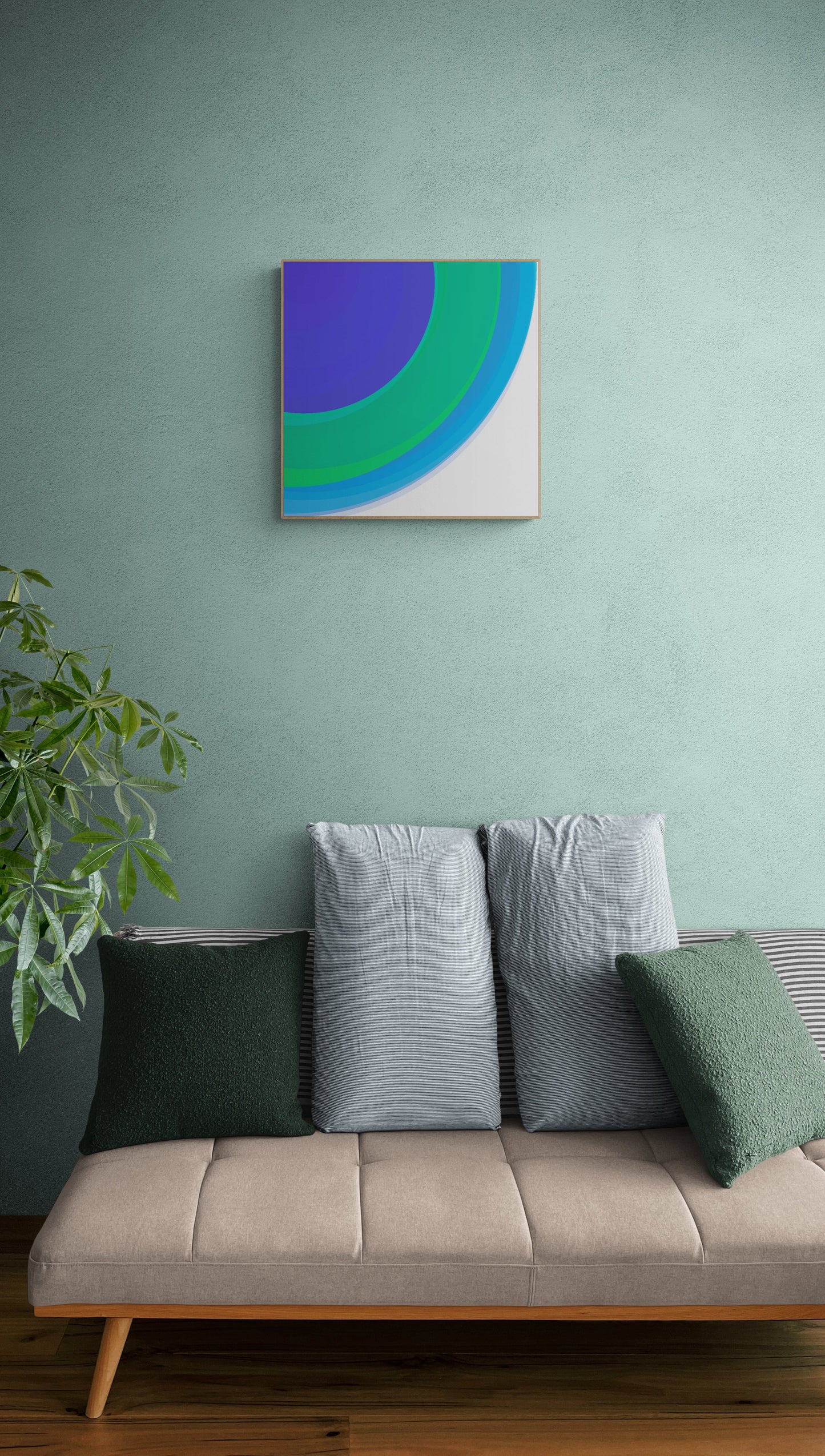 Sofa with decorative pillows against a light green wall with an art print of three concentric circles in blue, green, and purple on a white background