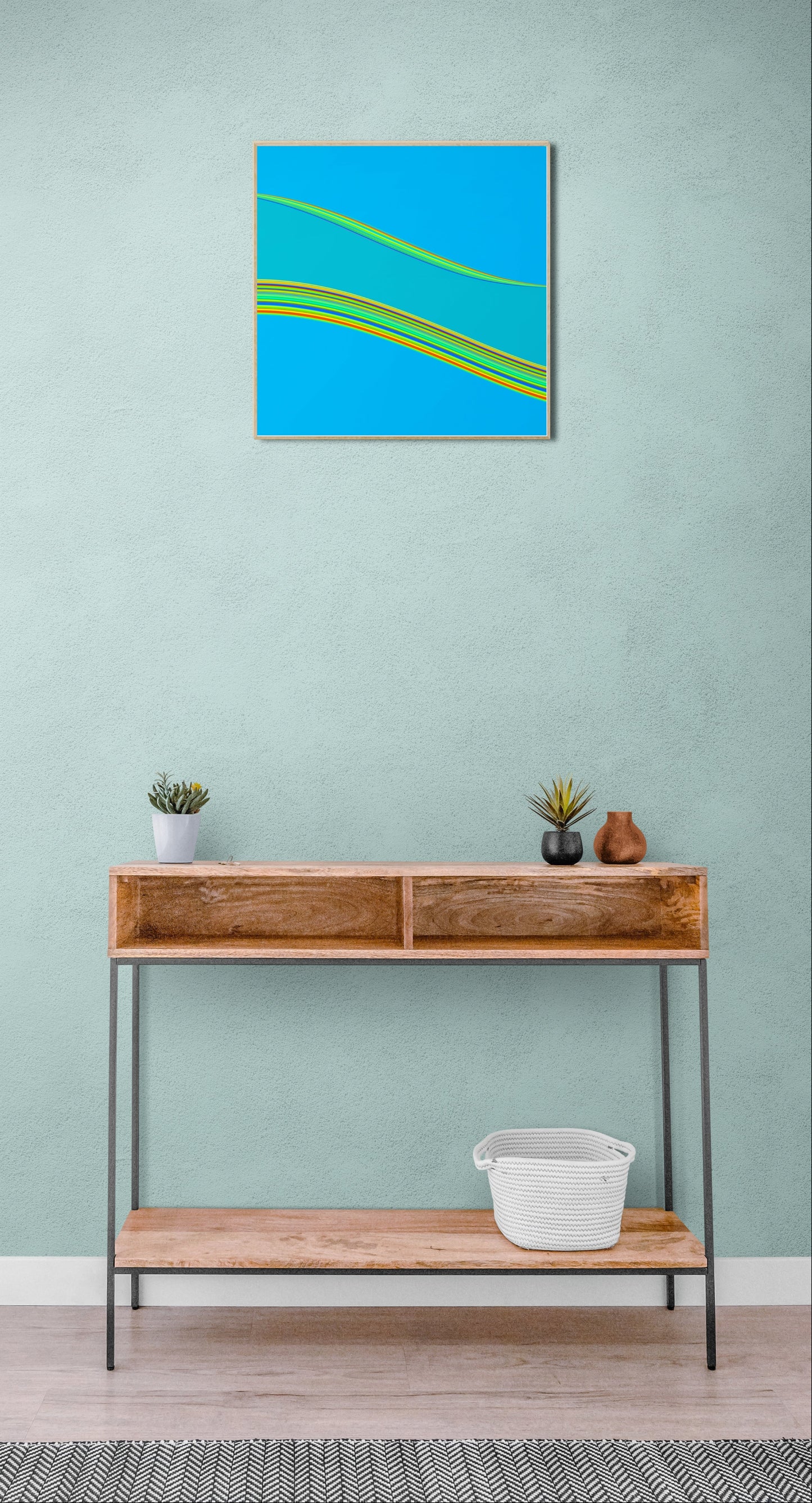 Wooden console table with decorative items against a light green wall with a framed abstract generative art print.