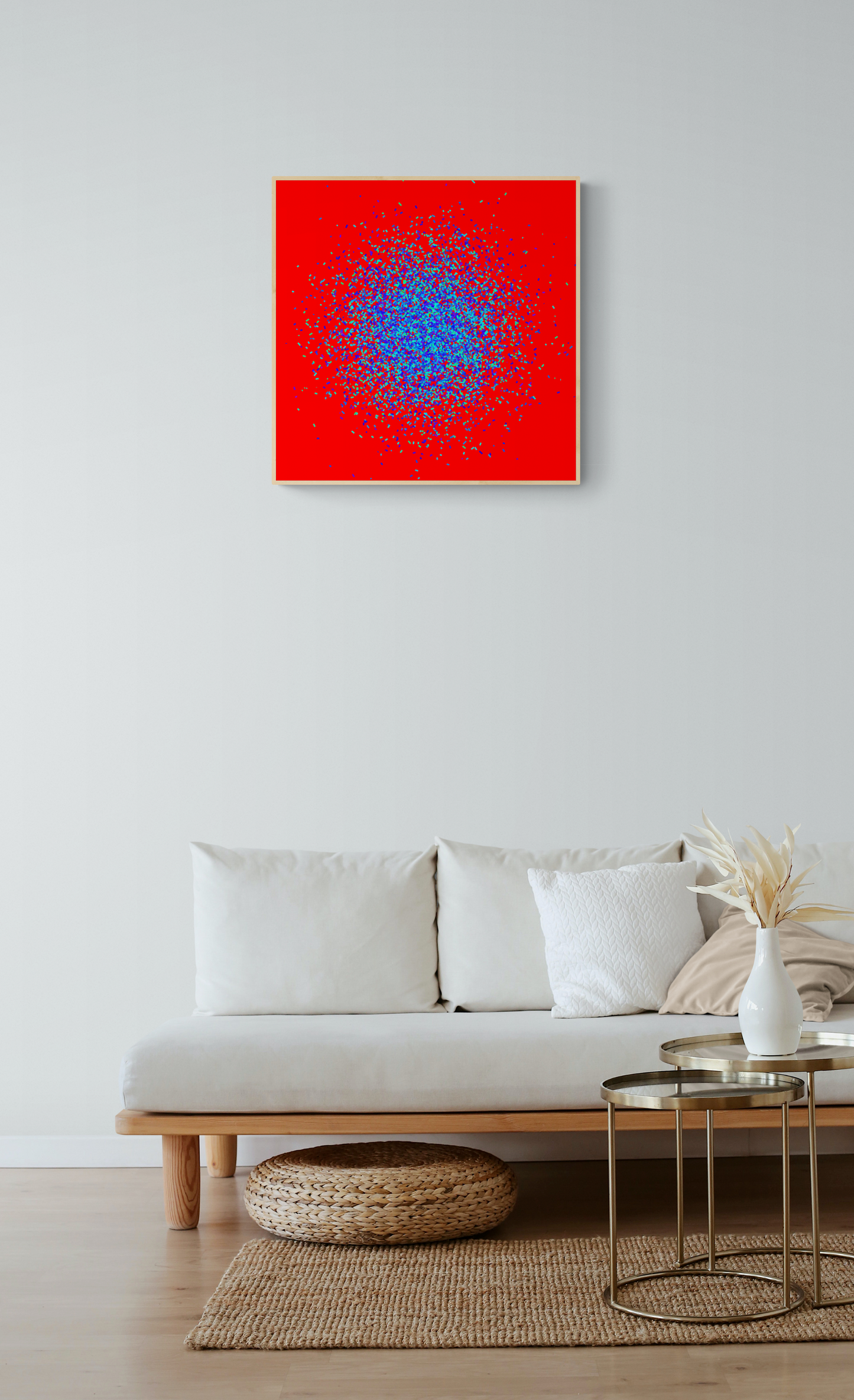 Abstract patterned art print of blue and green fragments on a red background on a white wall above a sofa.