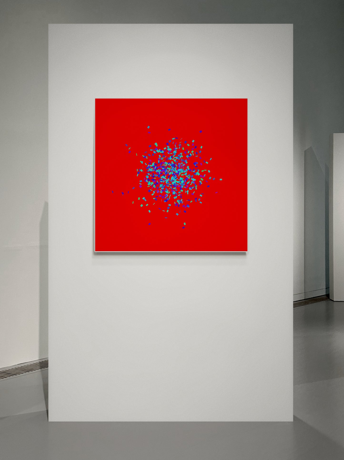 Blue, green, purple confetti like patterned abstract print on a red background in an art gallery.