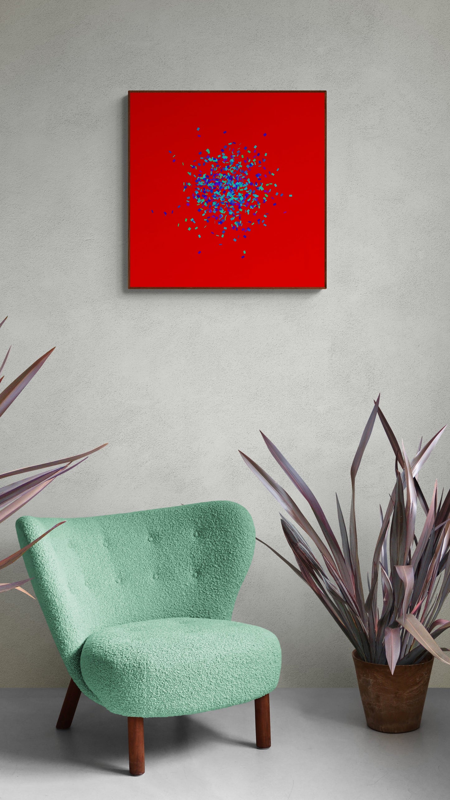 Green chair in front of a blue, green, purple confetti like patterned abstract print on a red background on a gray wall with plants.