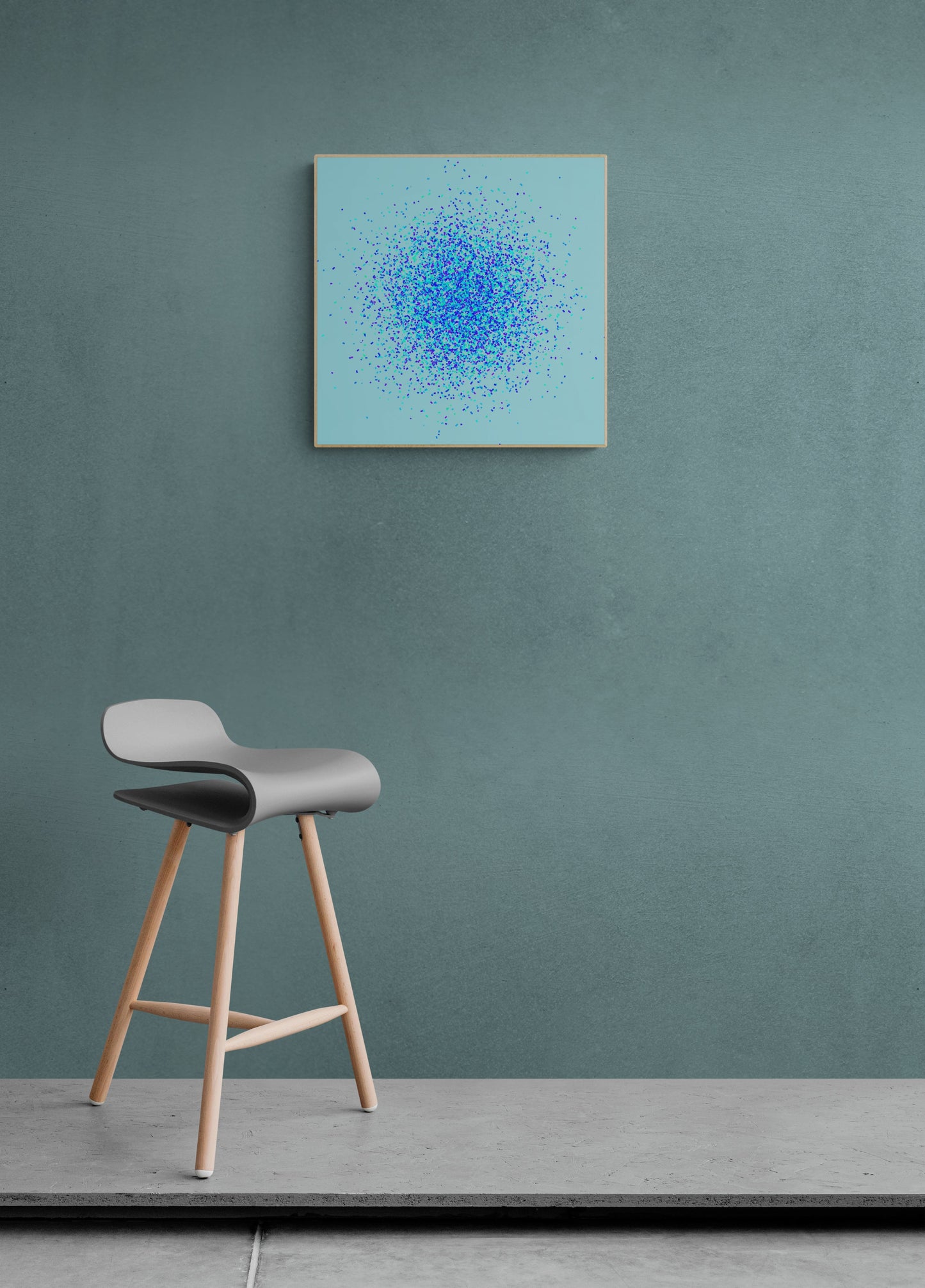 Abstract art print of blue, green and purple confetti like circular pattern on a light blue background on a teal wall with a gray stool below.