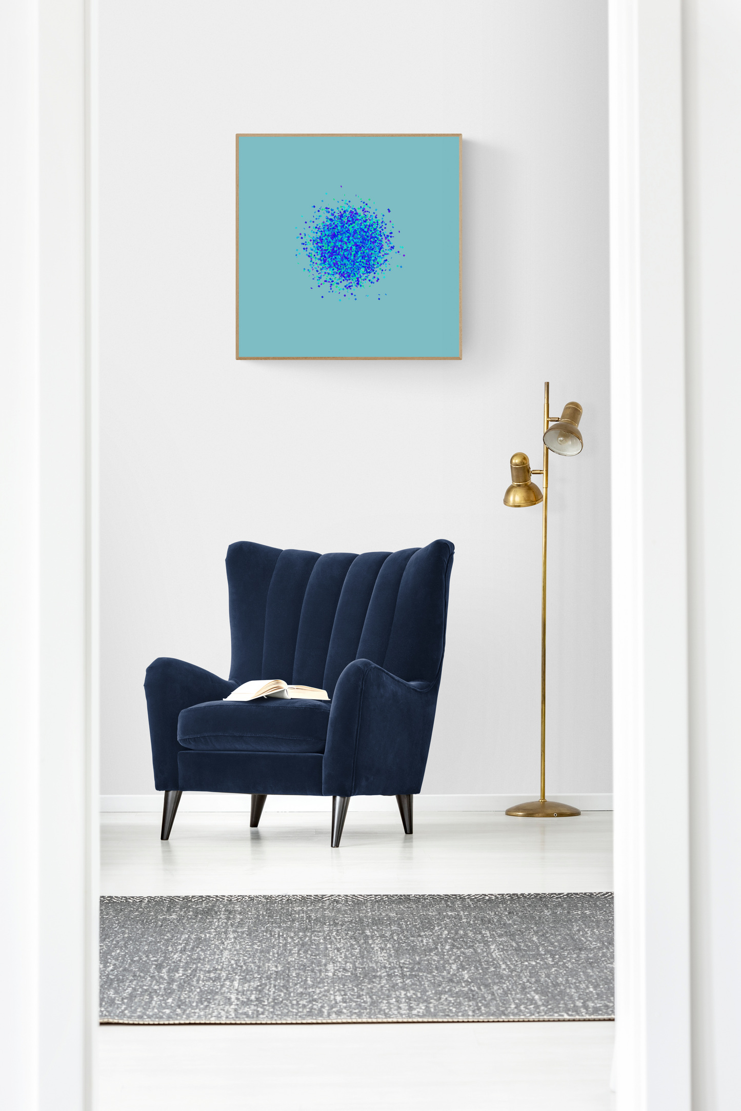 Navy blue armchair in a room with an abstract art print of blue, green and purple confetti like circular pattern on a light blue background on the wall.