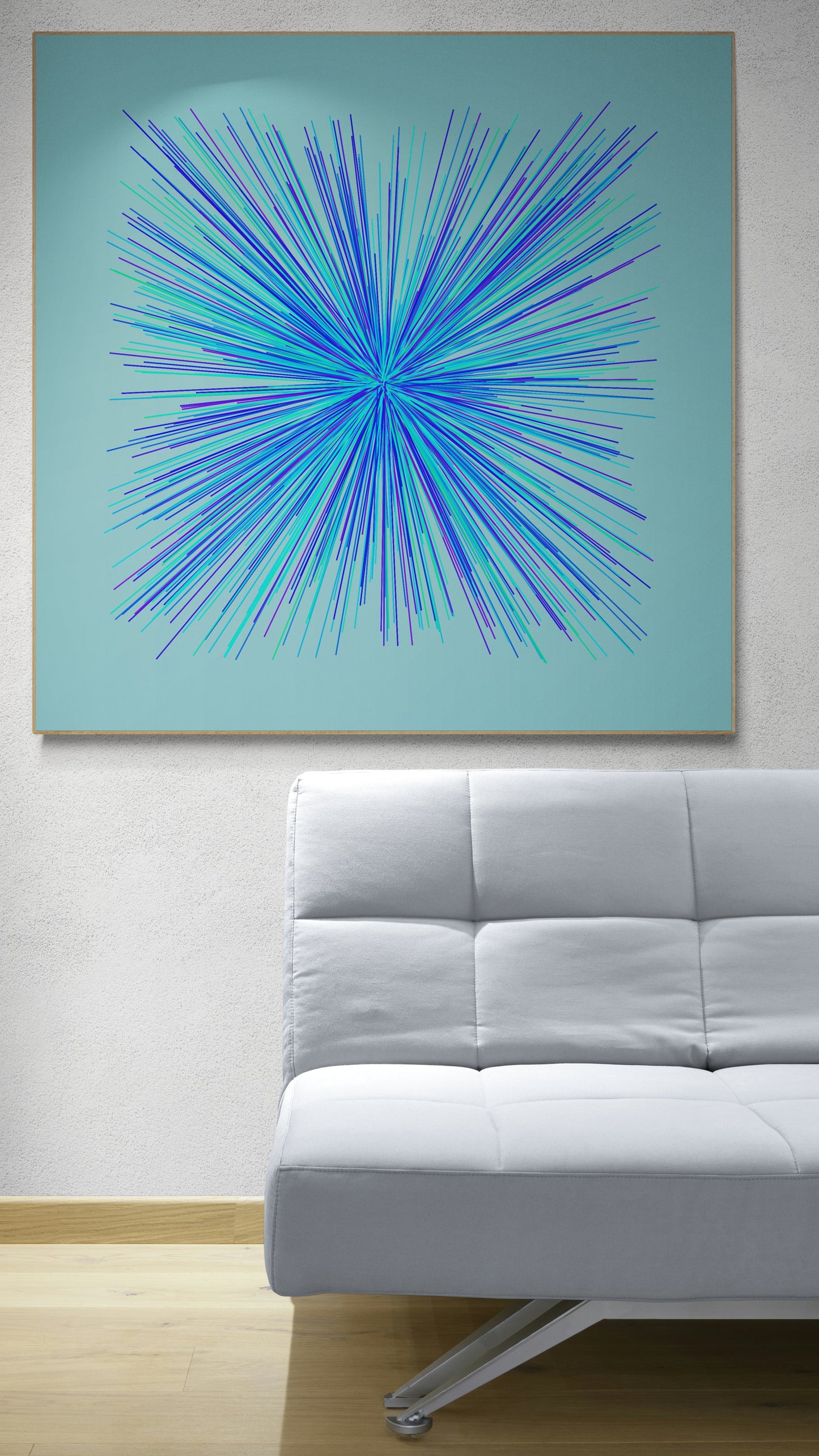 Abstract art print of blue, green and purple lines in a radial burst pattern on a light blue background on a light blue wall above a white sofa.