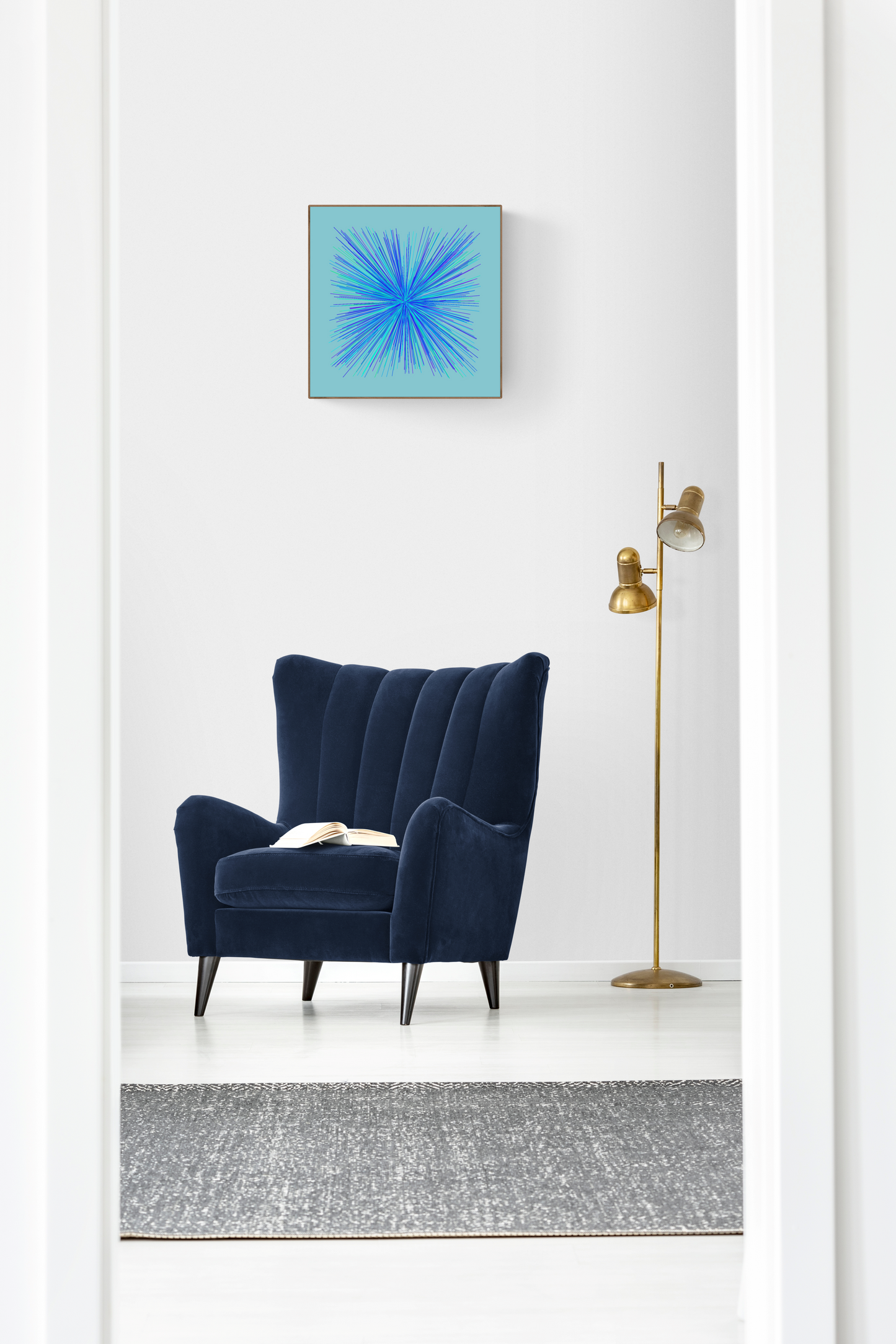 Navy blue armchair in a room with an abstract art print of blue, green and purple lines in a radial burst pattern on a light blue background on the wall.