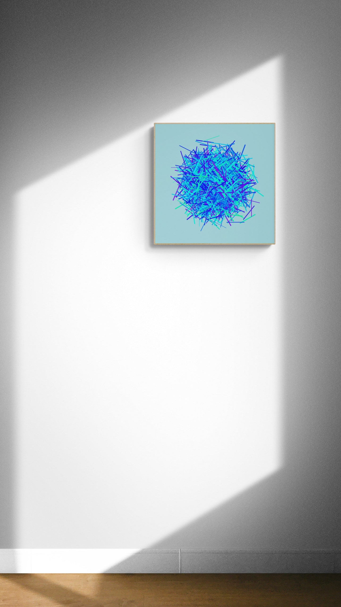 Abstract art print of blue, green and purple lines in a circular pattern on a light blue background on a white wall with a light source casting shadows.