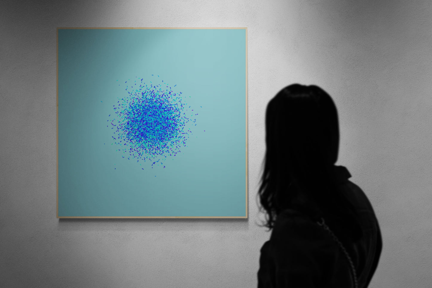 Person viewing an abstract art print of blue, green and purple confetti like circular pattern on a light blue background on a teal background