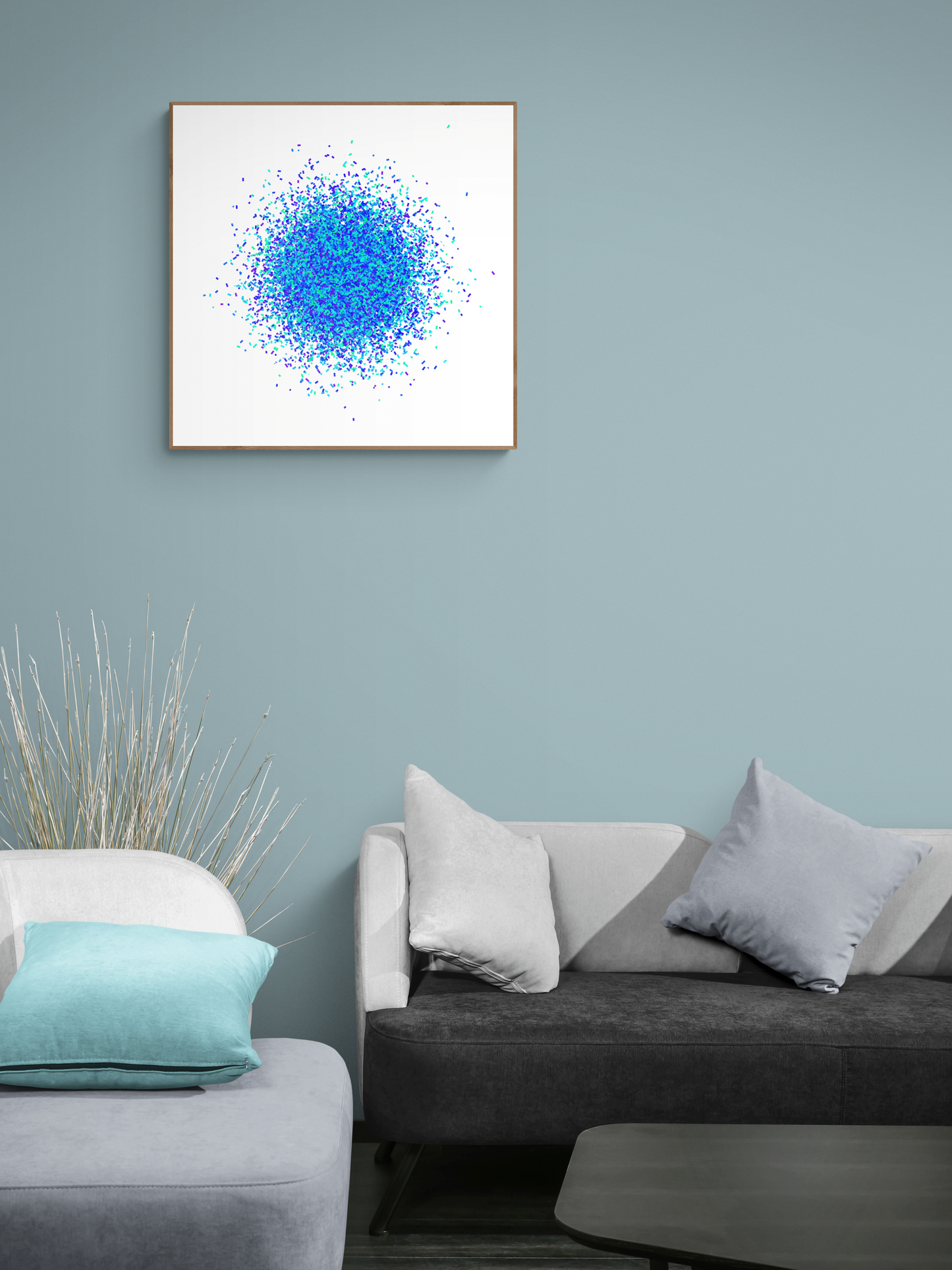 Framed abstract art print with blue and white colors on a wall above a sofa.