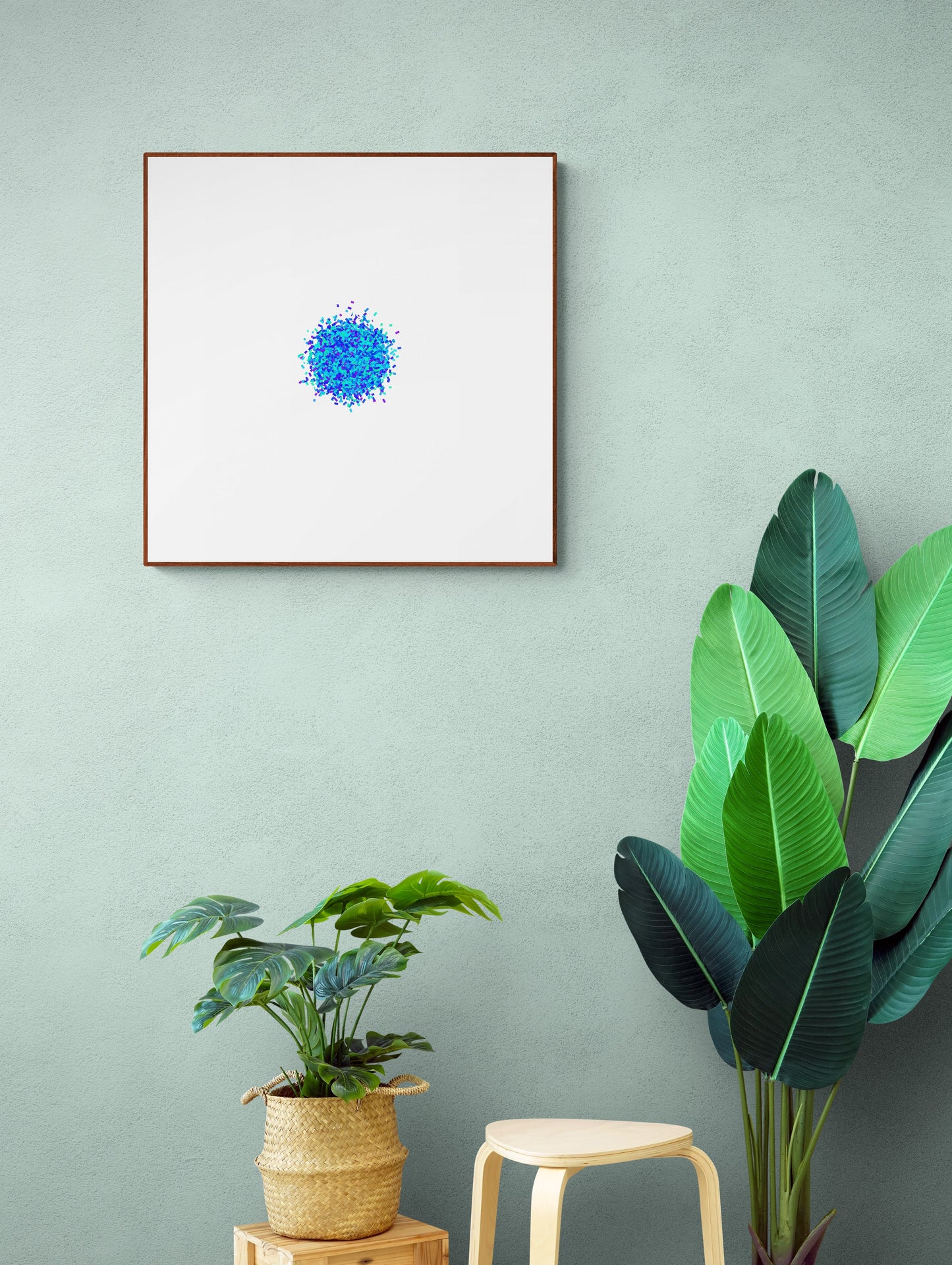 Blue and green colour particle like circle abstract art print on a white background on a light green wall, with plants and a stool below.
