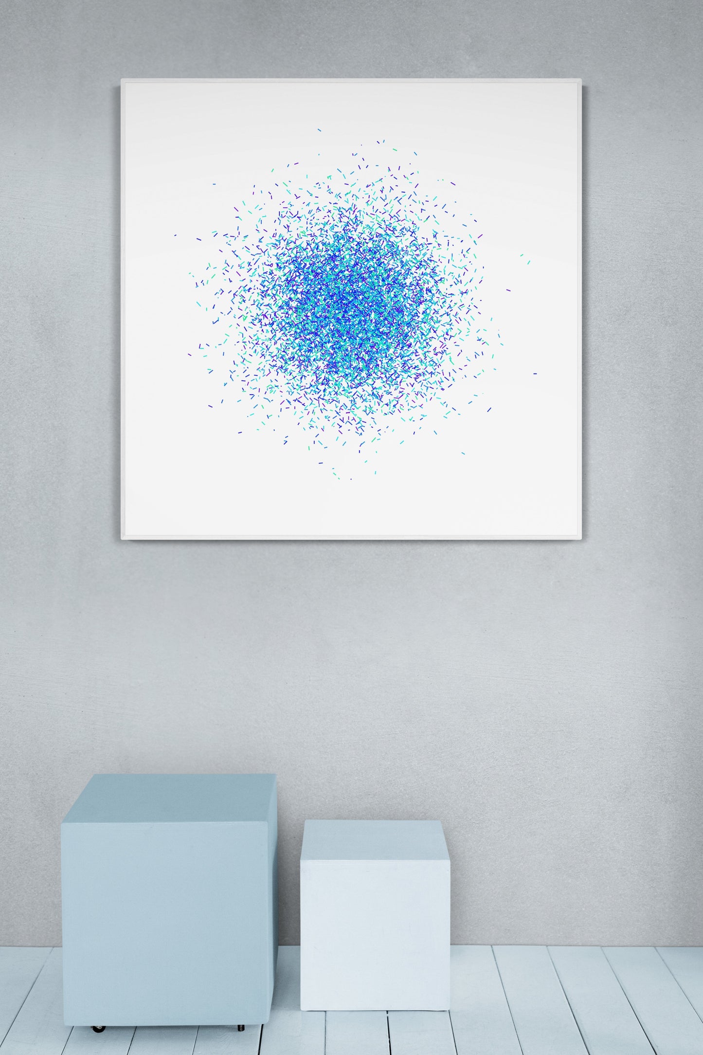 Blue and green confetti like patterned abstract print on a white background on a gray wall.