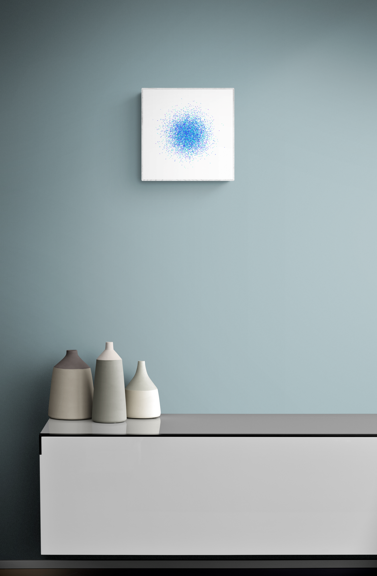Three ceramic vases on a shelf against a gray wall with a blue and green confetti like patterned abstract print on a white background above.