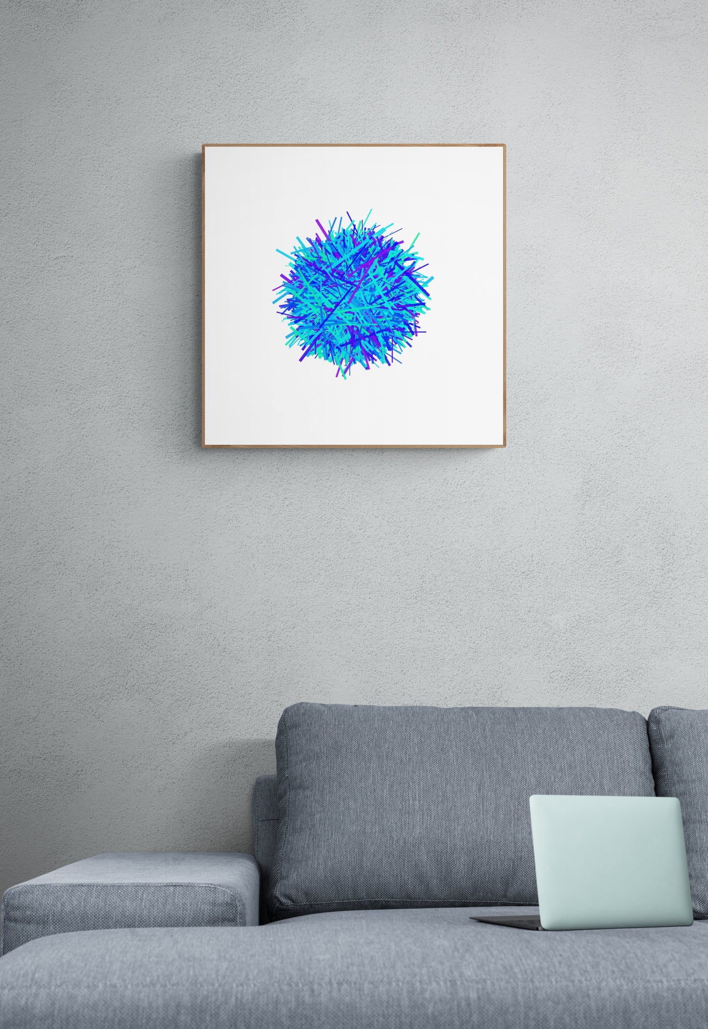 Framed abstract blue and green art print on a gray wall above a gray sofa with a light blue pillow.