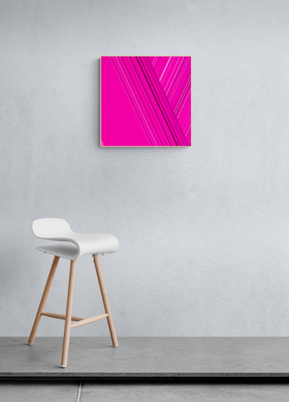 Art print  of abstract design with intersecting lines on a pink backgroundon a gray wall with a white stool below.