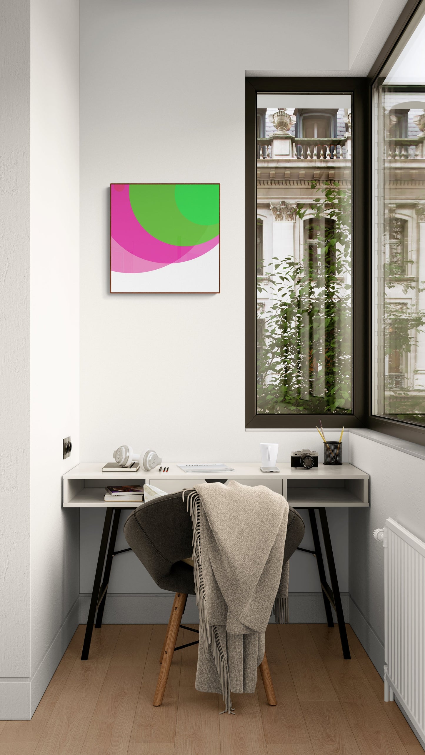 Modern home office with a desk, chair, and art print of two overlapping circles, one green and one pink, on a white background