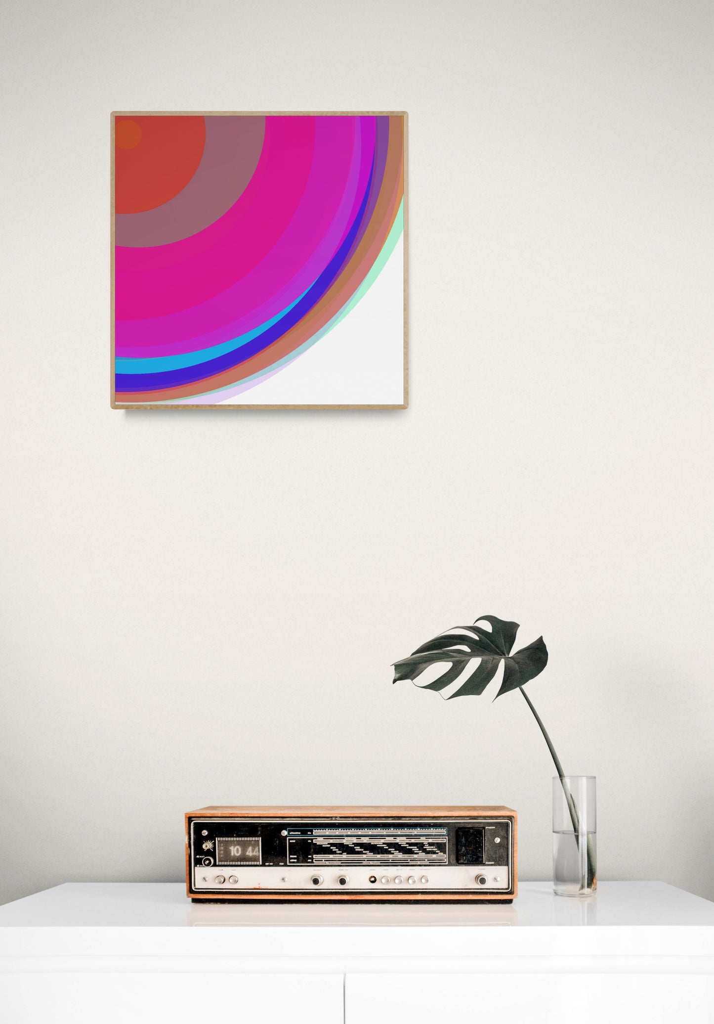 Art print of colorful circular spheres with a gradient effect  on a white wall above a vintage radio.