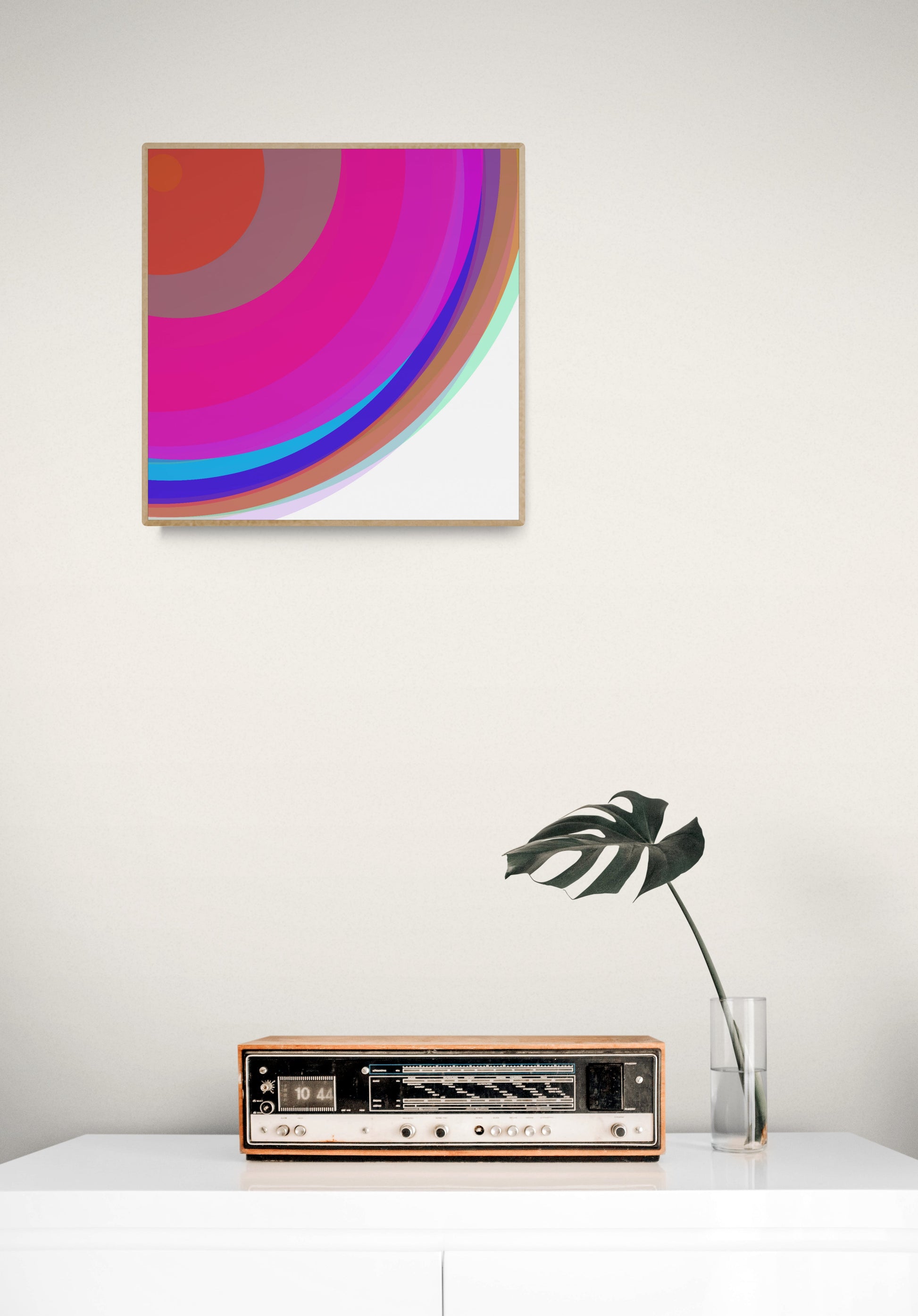 Art print of colorful circular spheres with a gradient effect  on a white wall above a vintage radio.
