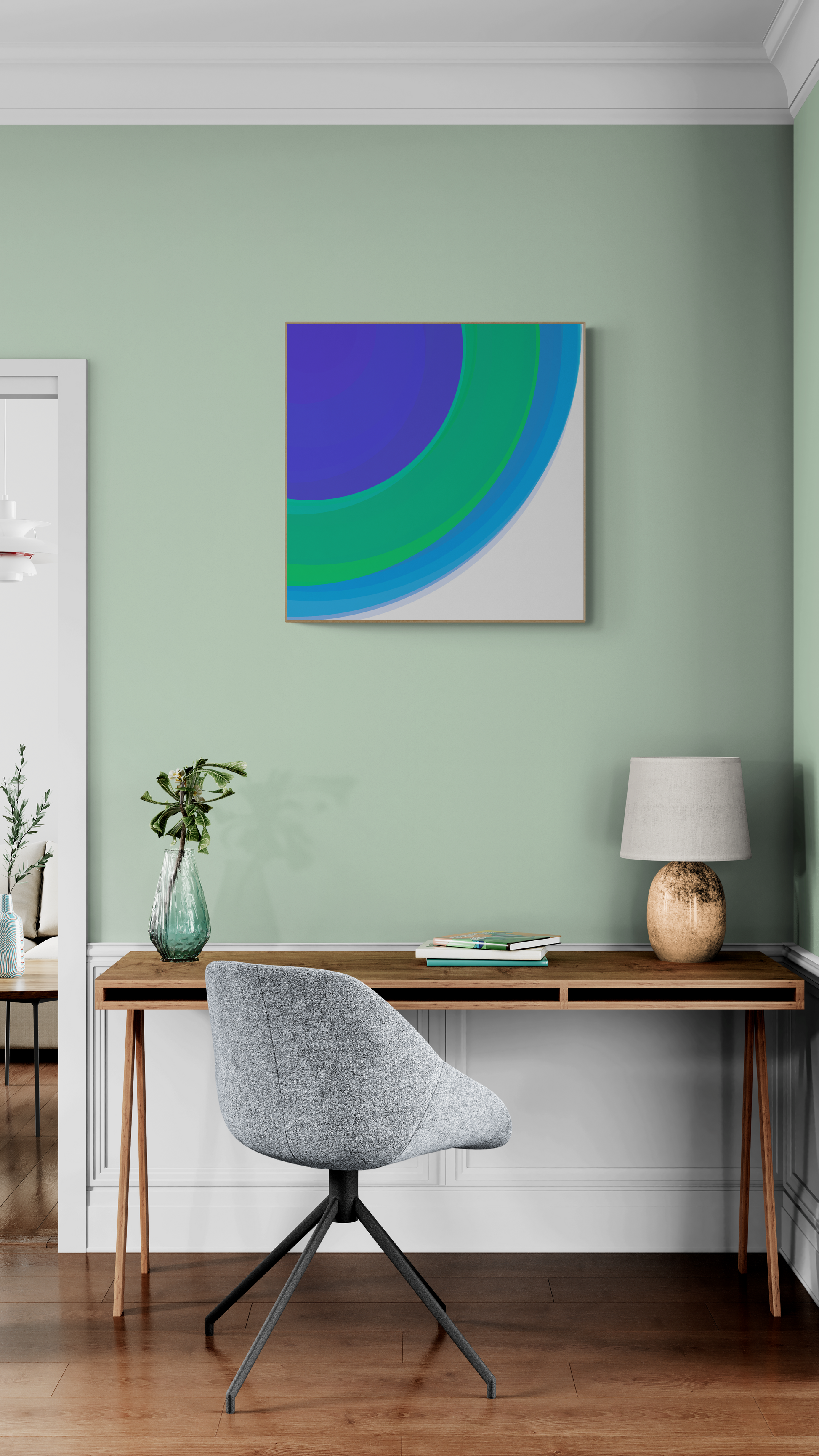 Modern home office with a desk, chair, and art print of three concentric circles in blue, green, and purple on a white background on a green wall.