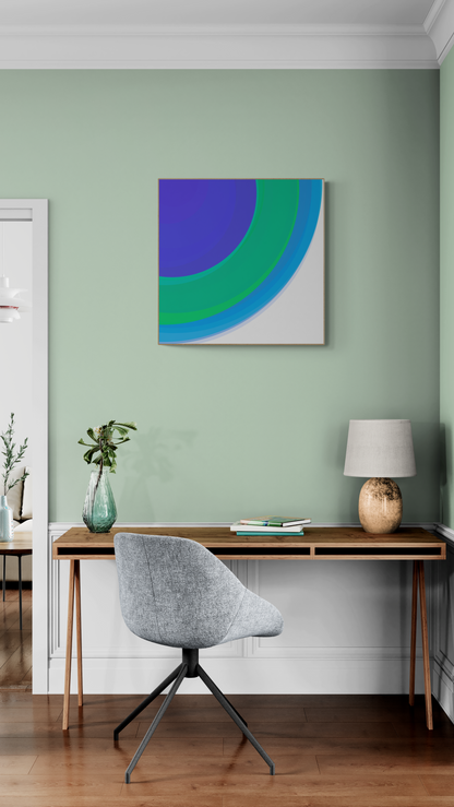 Modern home office with a desk, chair, and art print of three concentric circles in blue, green, and purple on a white background on a green wall.