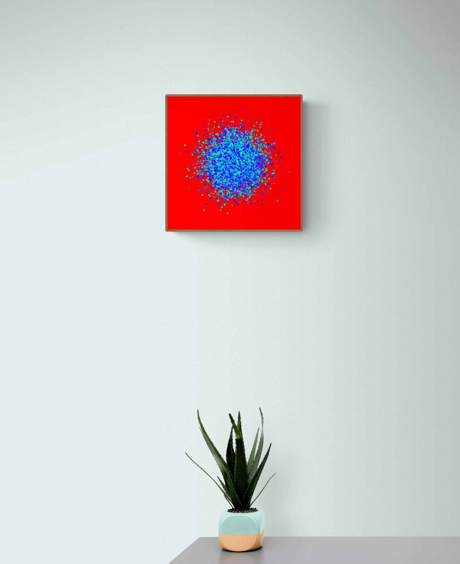 Blue, green, purple confetti like patterned abstract print on a red background, placed above a potted plant on a gray surface.