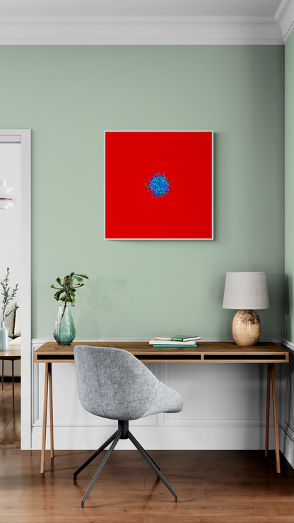 Abstract patterned art print of ball of blue and green fragments on a red background on a green wall, a desk, and chair.