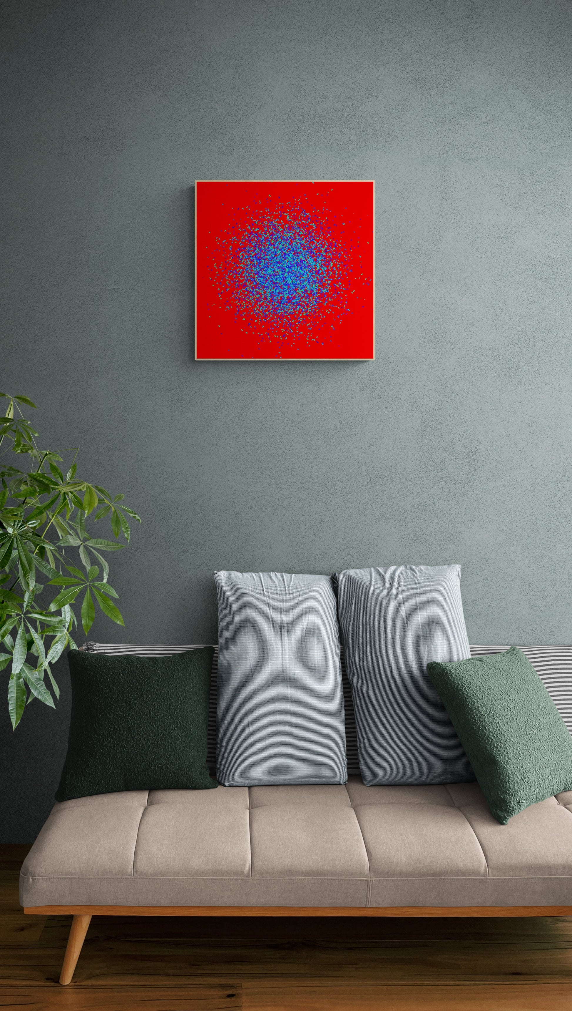 Framed abstract patterned art print of  blue and green fragments on a red background on a gray wall above a beige sofa with green and gray cushions.