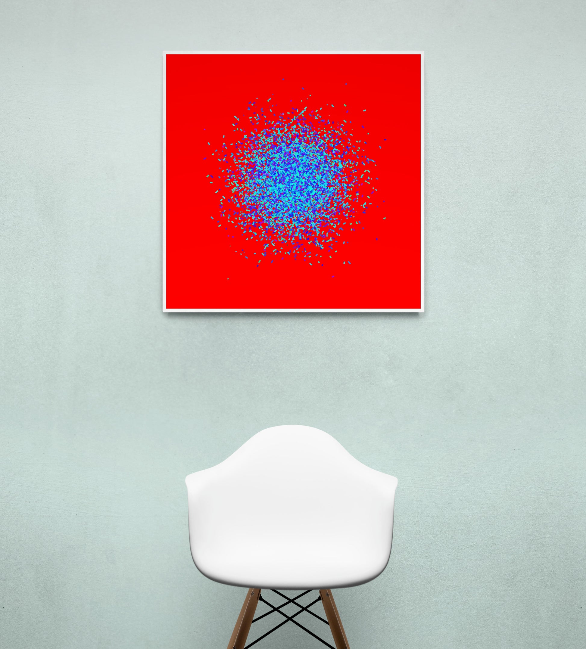 Abstract circle patterned art print of blue and green fragments on a red background, displayed on a light gray wall with a white chair below.