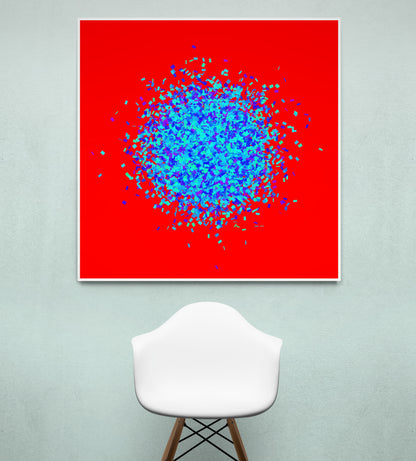 Blue, green, purple confetti like patterned abstract print on a red background, displayed on a light gray wall with a white chair.