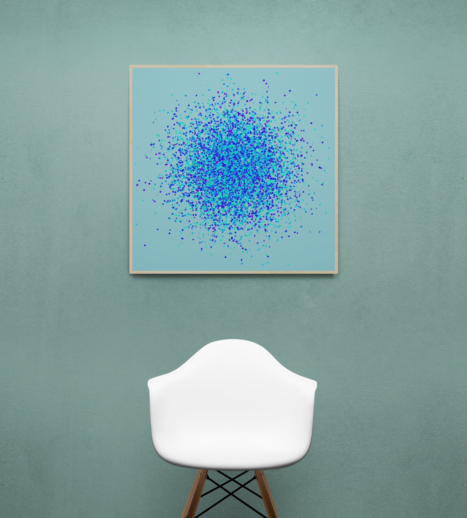 Abstract art print of blue, green and purple confetti like circular pattern on a light blue background, displayed on a green wall with a white chair.