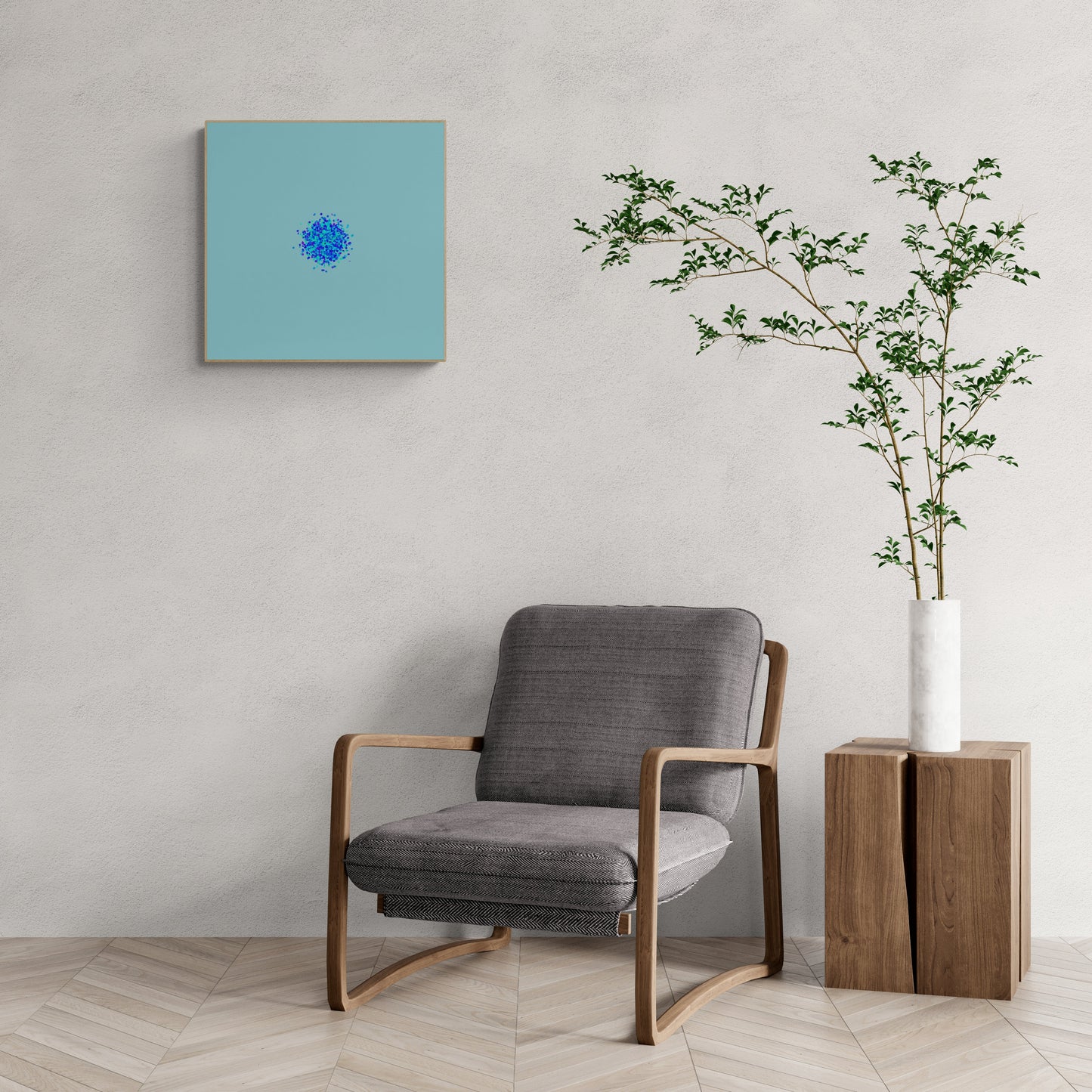 Gray armchair in a room with an abstract art print of blue, green and purple confetti like circular pattern on a light blue background on the wall and a plant in a white vase.