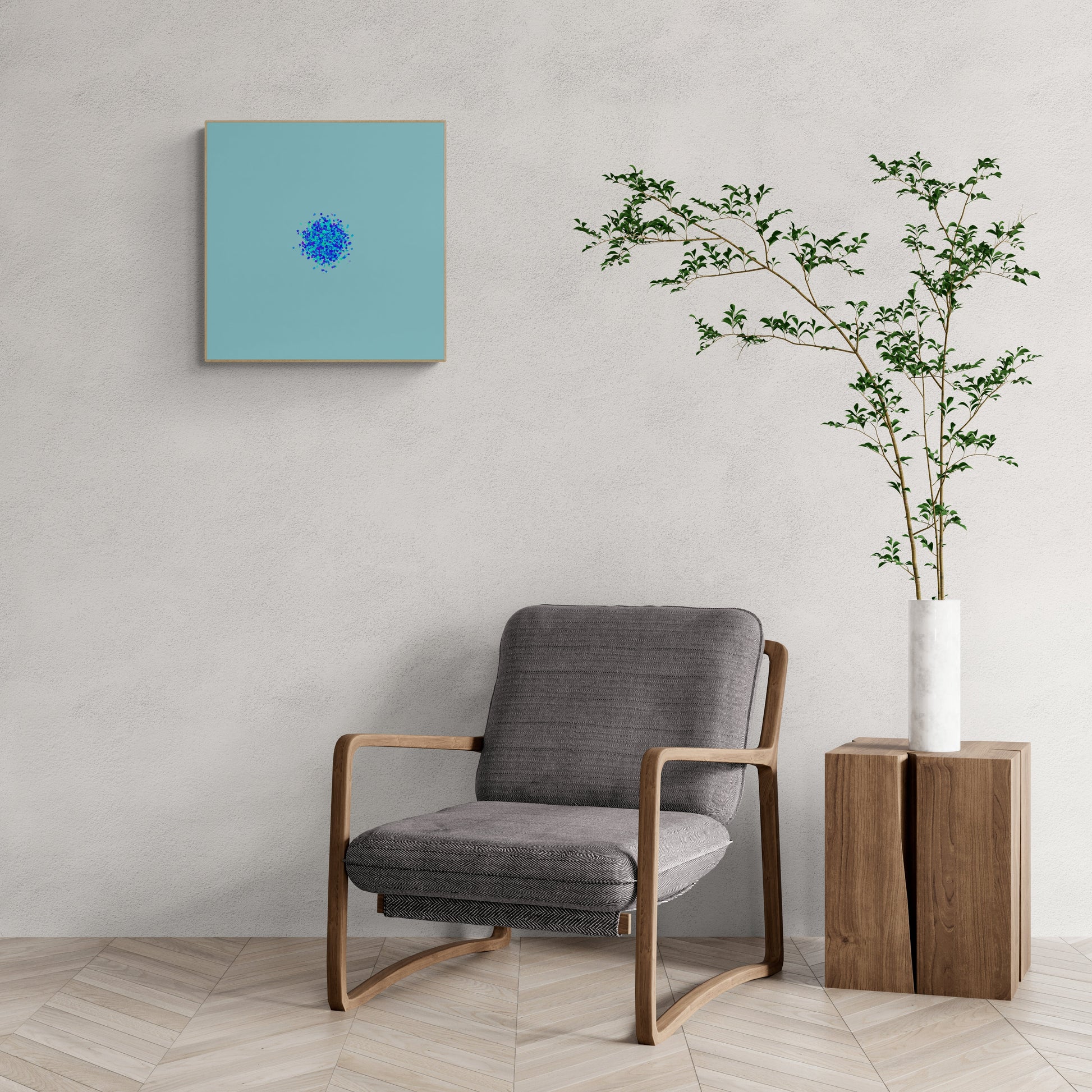 Gray armchair in a room with an abstract art print of blue, green and purple confetti like circular pattern on a light blue background on the wall and a plant in a white vase.