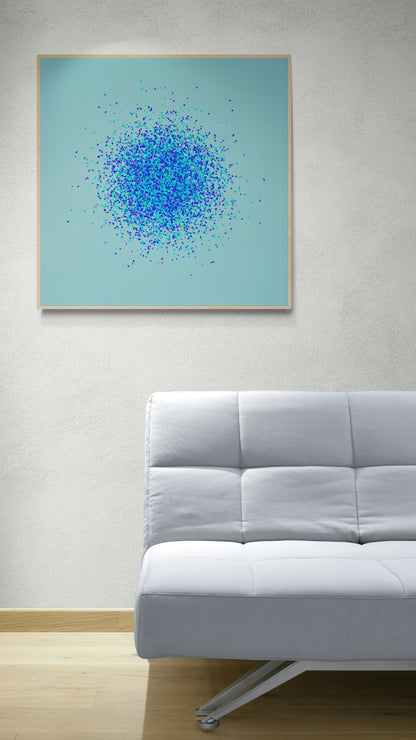 Framed abstract art print of blue, green and purple confetti like circular pattern on a light blue background on a light blue background, displayed above a gray sofa.
