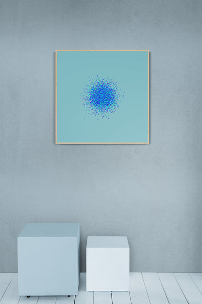 Framed abstract art print of blue, green and purple confetti like circular pattern on a light blue background on a light gray wall.