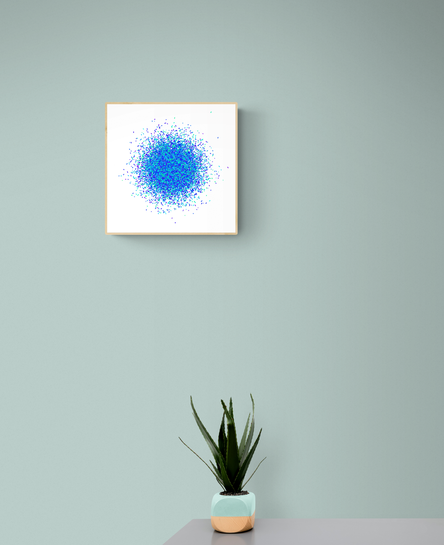 Framed abstract artwork print with blue and white pattern on a light gray wall, accompanied by a potted plant.