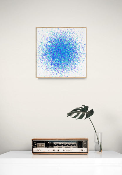 Colorful abstract blue and green dot like patterned art print above a vintage radio on a white surface.