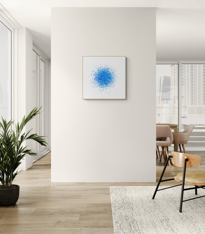 Modern interior with a blue and green speckle patterned abstract art print on a white background on a white wall, a plant, and a chair.