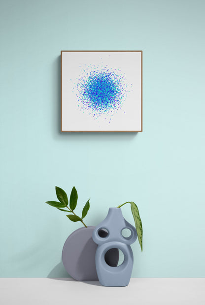 Framed abstract art print with blue and  green pattern on a light blue wall, accompanied by a gray vase and plant.